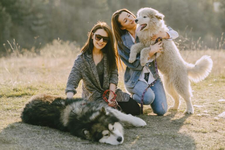 Photo of Women Holding Their Dogs