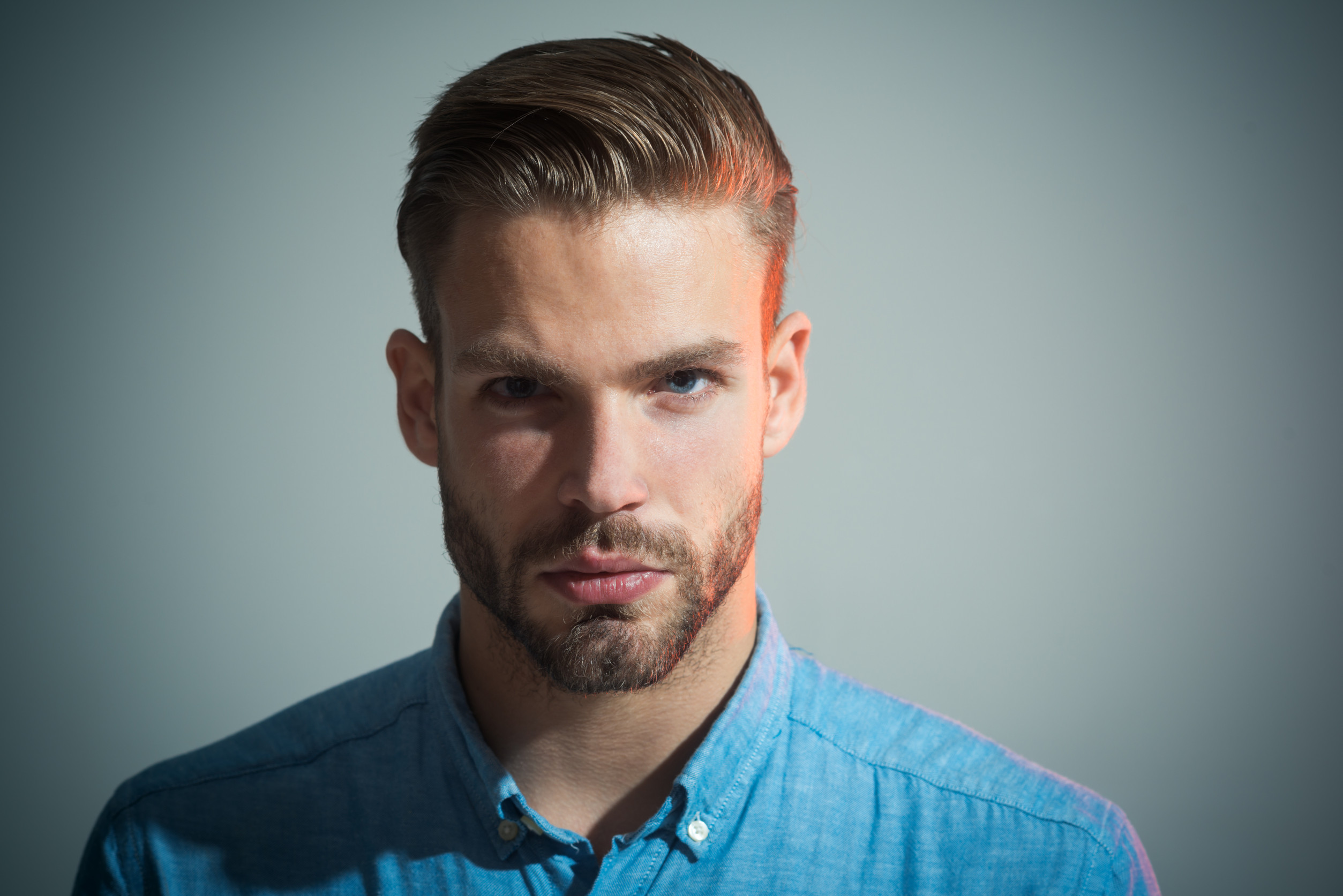 Confident successful male model in blue shirt. Pensive smart serious businessman. Attractive handsome man with beard&mustache. Fashion portrait of man with serious face. Thoughtful guy.Face expression