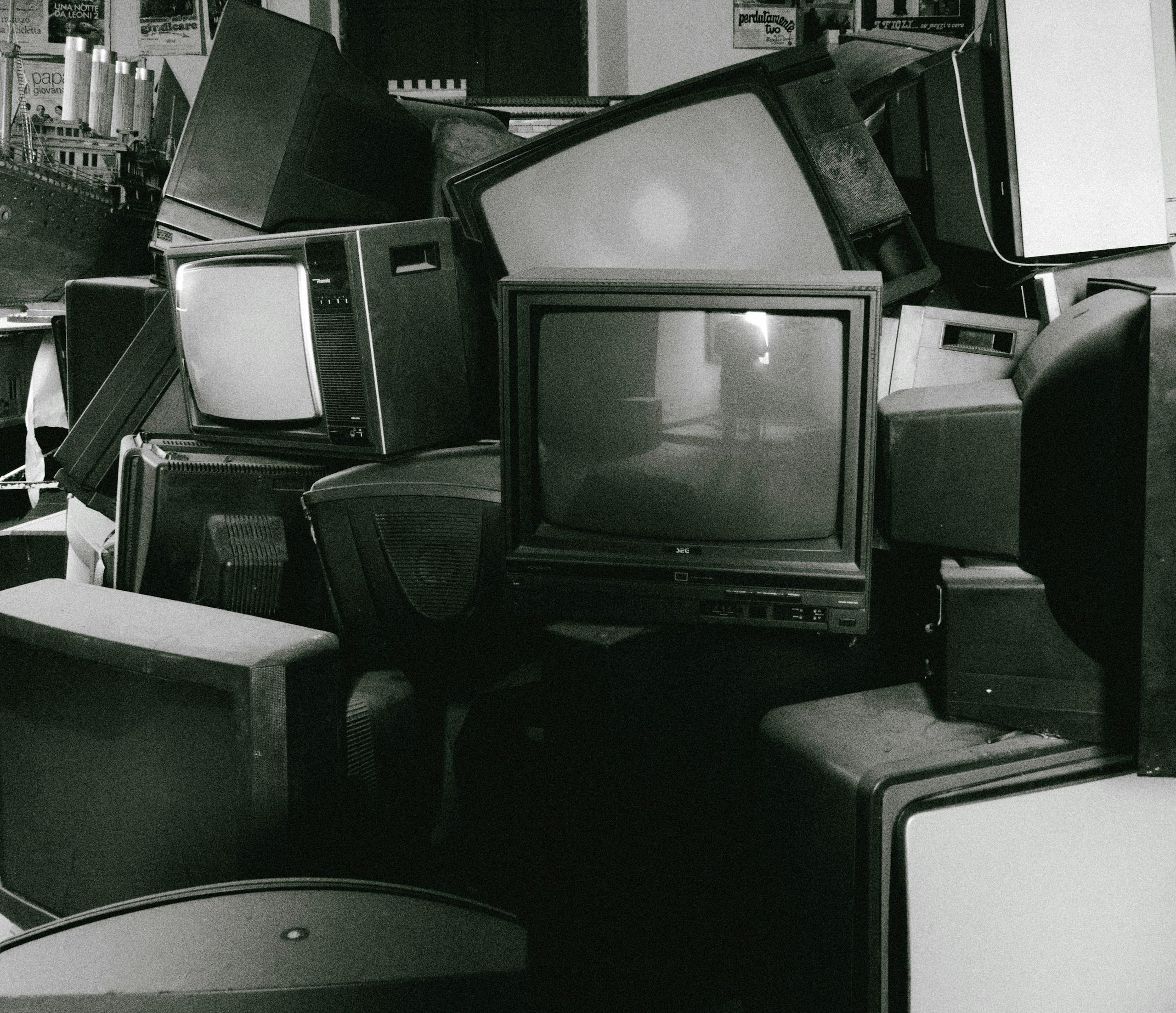 A stack of retro televisions evokes nostalgia and past technology in black and white.