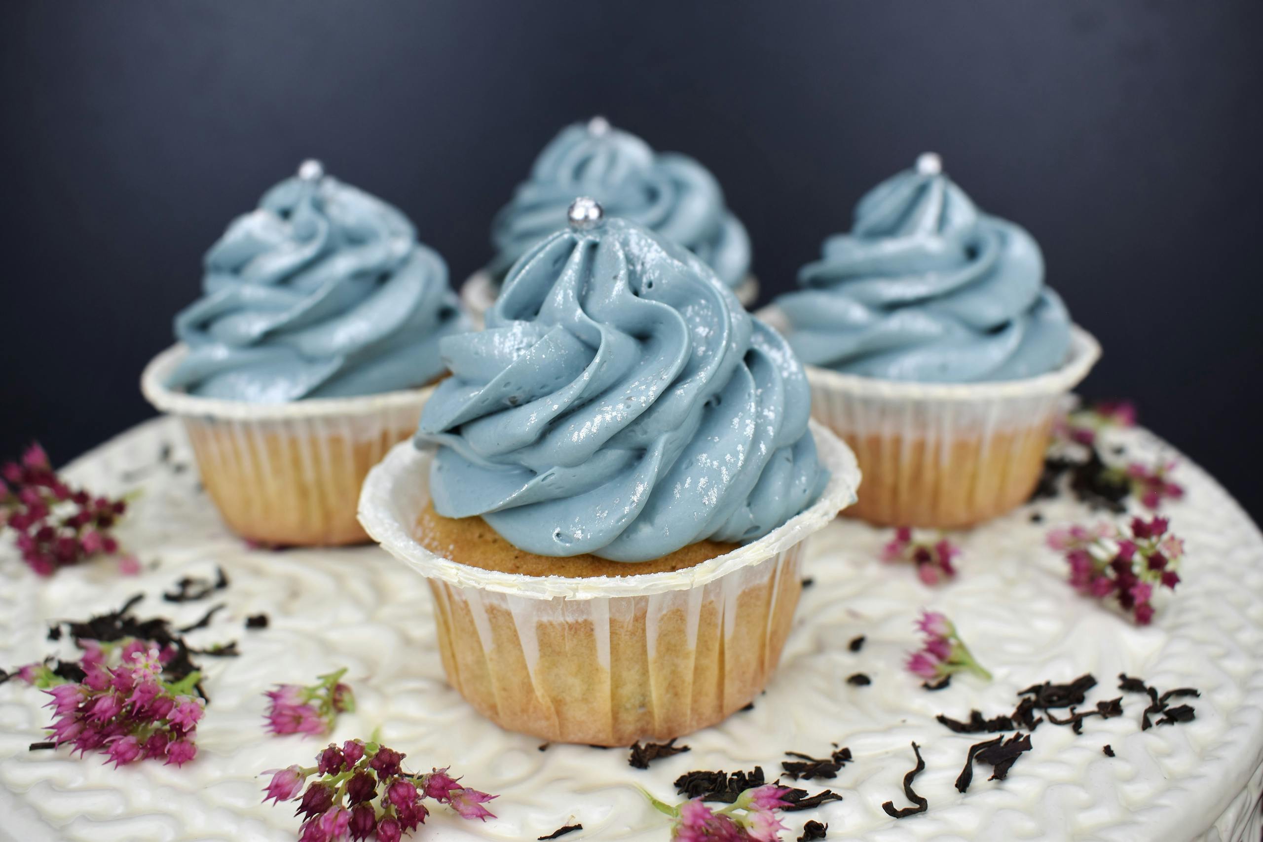 Close-up of blue frosted cupcakes with floral decoration. Perfect for parties and celebrations.