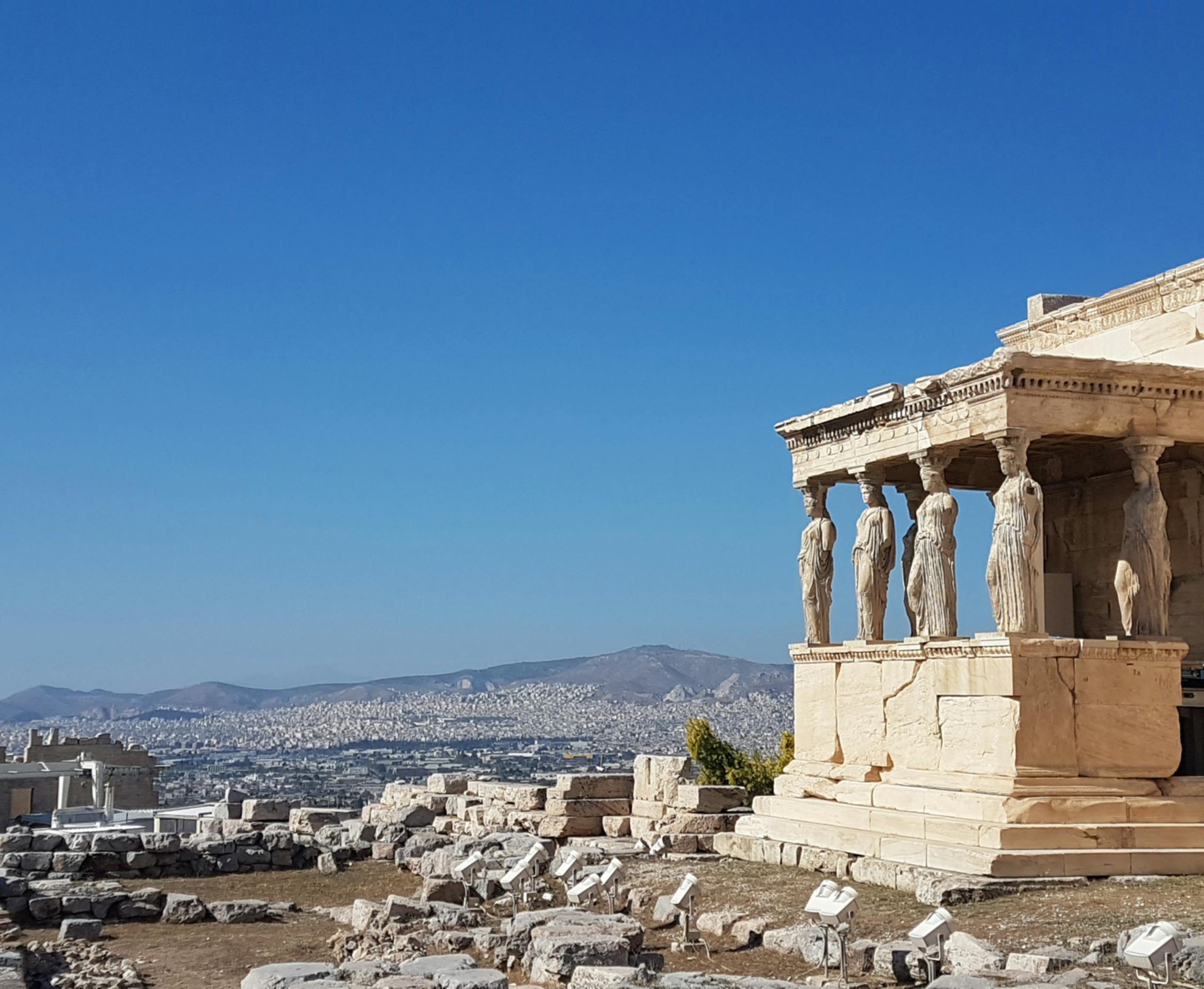 Erechtheion Temple with Caryatids in Acropolis, Athens under a clear blue sky.