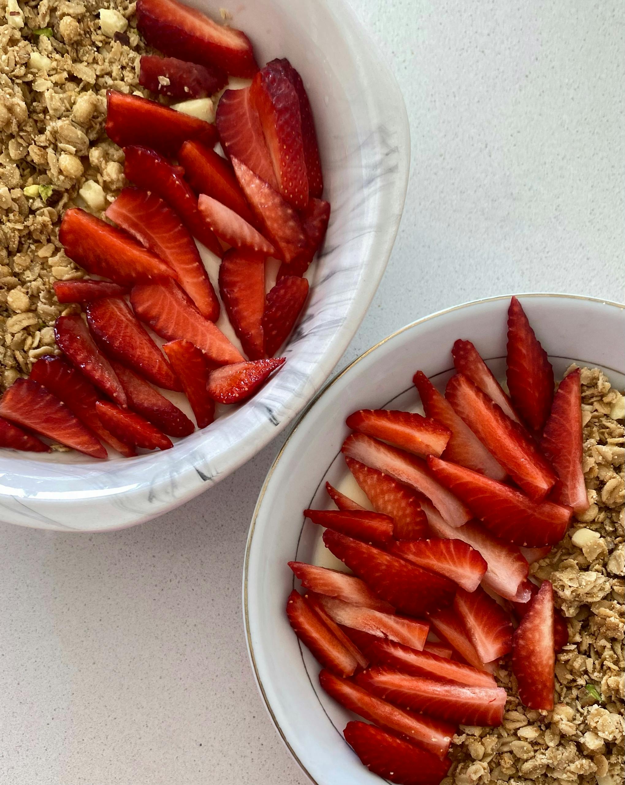 Top view of granola bowls with fresh strawberries, vibrant and healthy breakfast option.