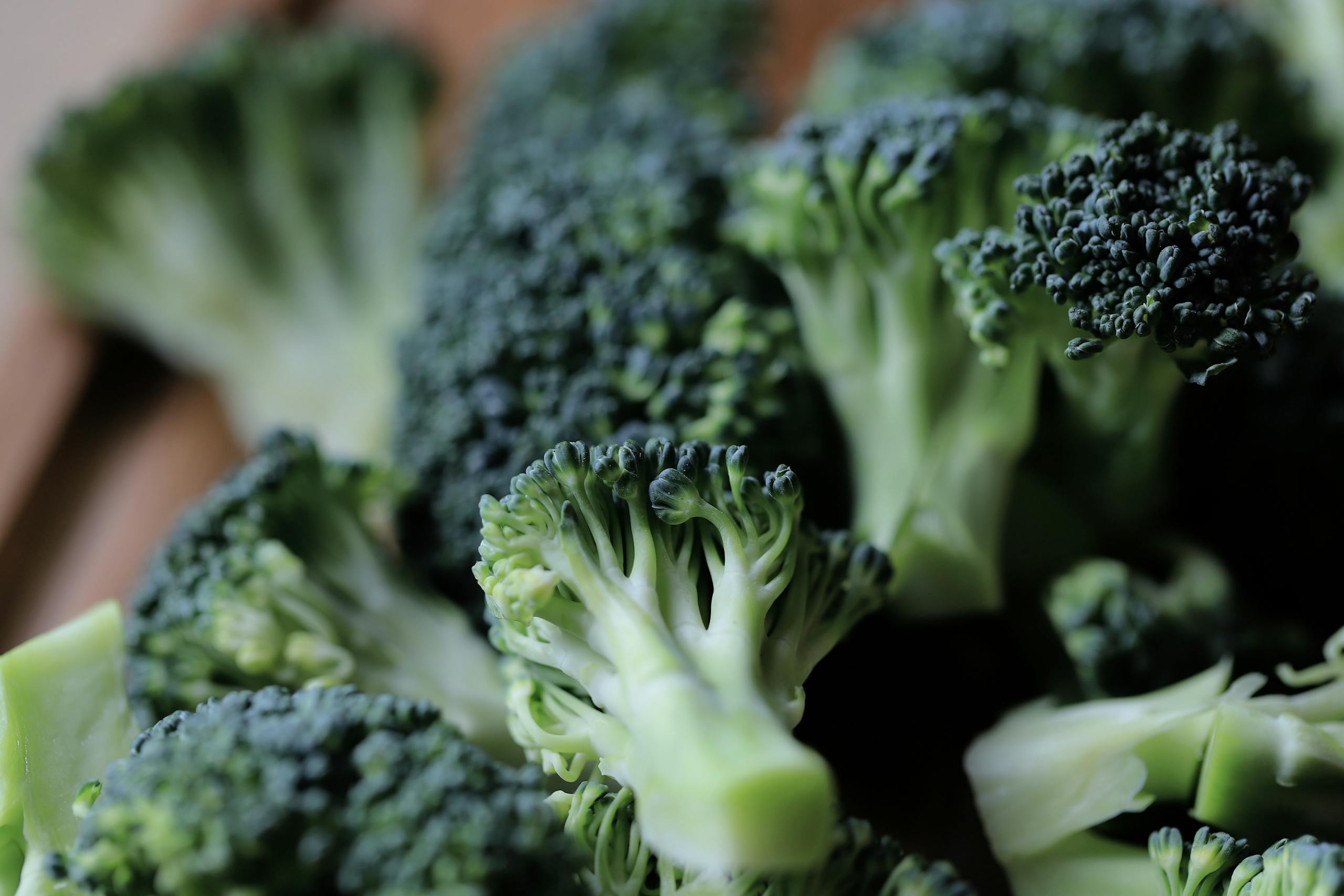 Close-up of fresh green broccoli florets on a kitchen chopping board, ready for cooking.