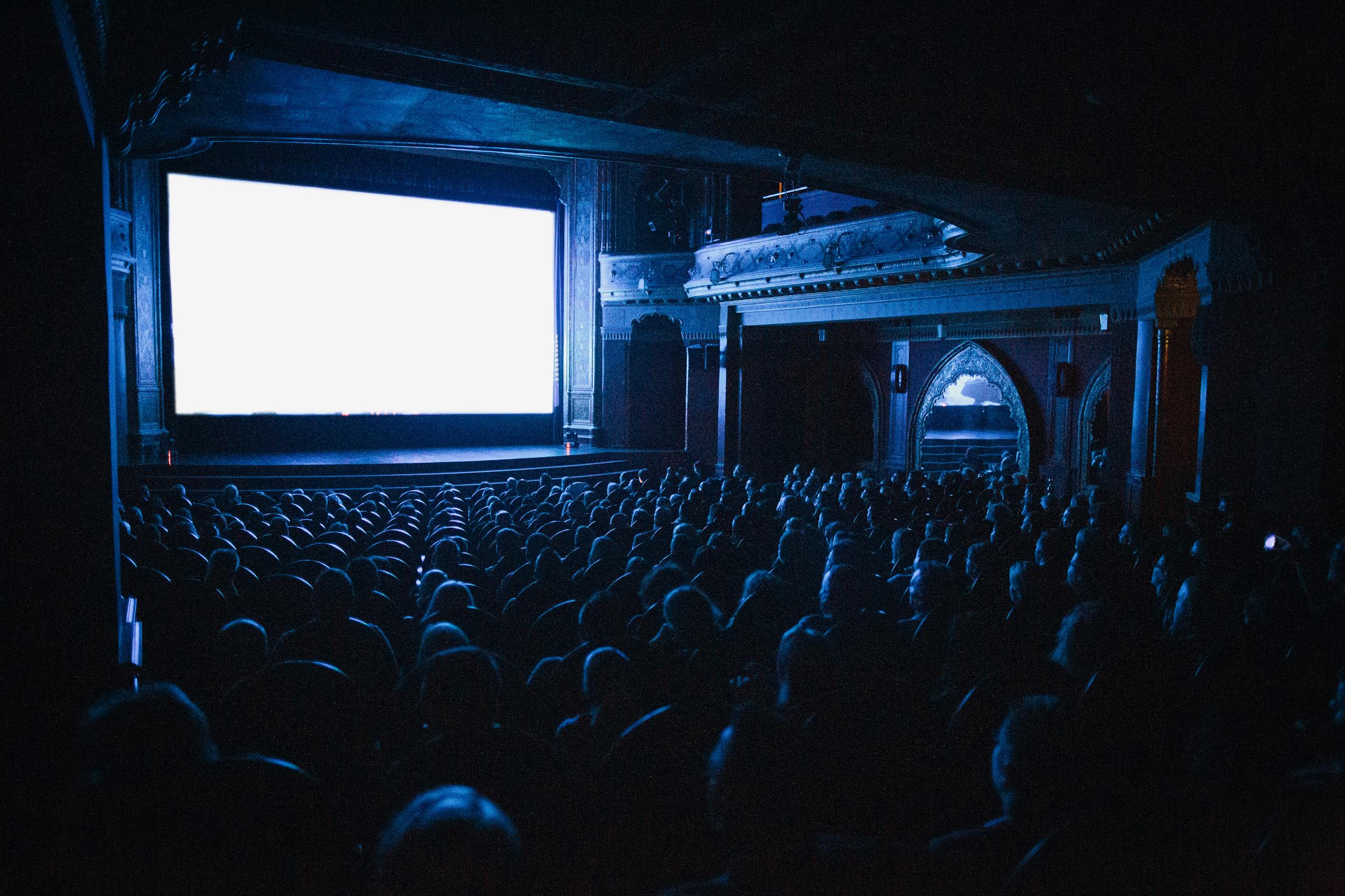 A full cinema theater in Budapest with an audience watching a movie at night.
