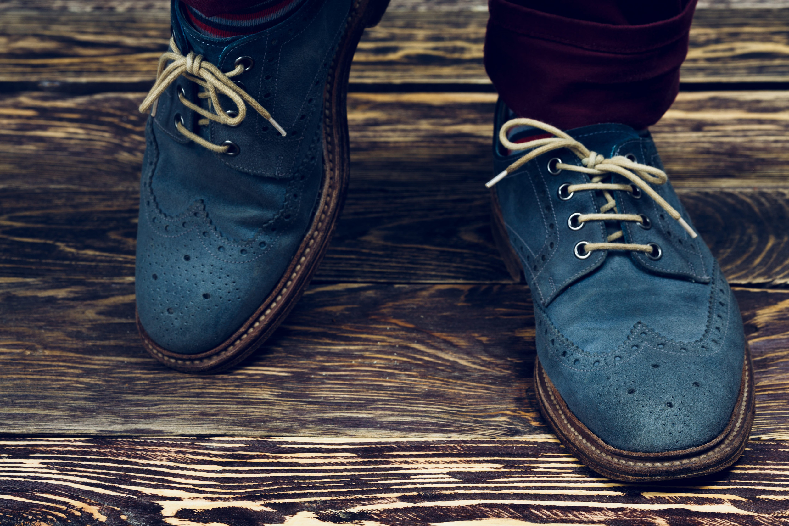 Close up of men's brogues (also known as derbies,gibsons or wingtips) made from blue oiled suede. Vintage styled