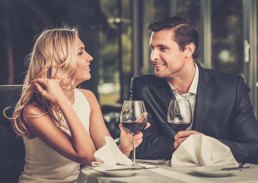 Cheerful couple in a restaurant with glasses of red wine