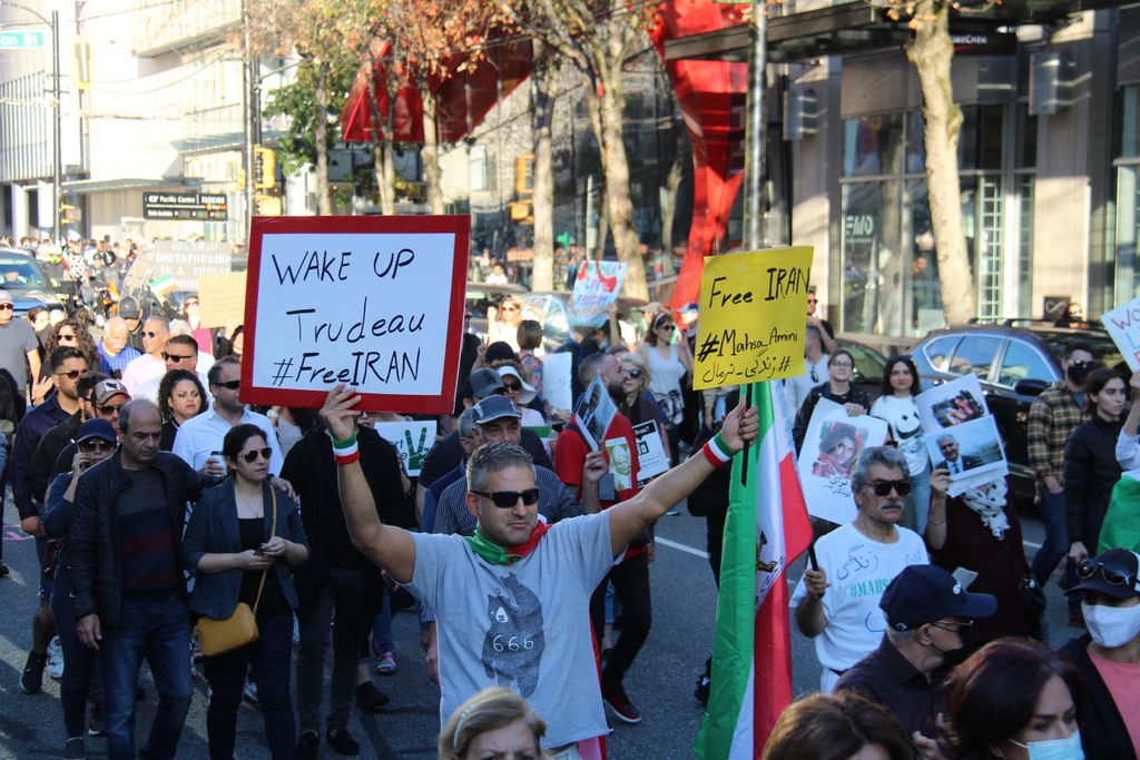 A peaceful protest in Vancouver advocating for Iranian freedom and justice with placards.