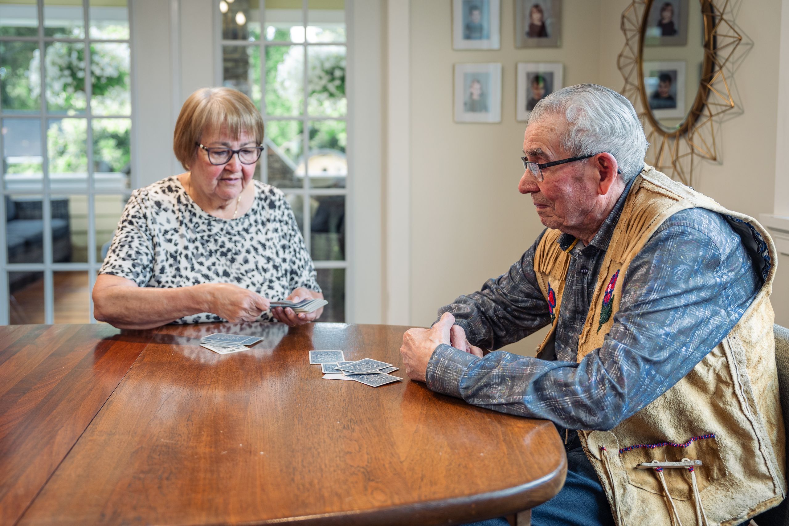 Senior couple playing cards at home, fostering connection and fun.