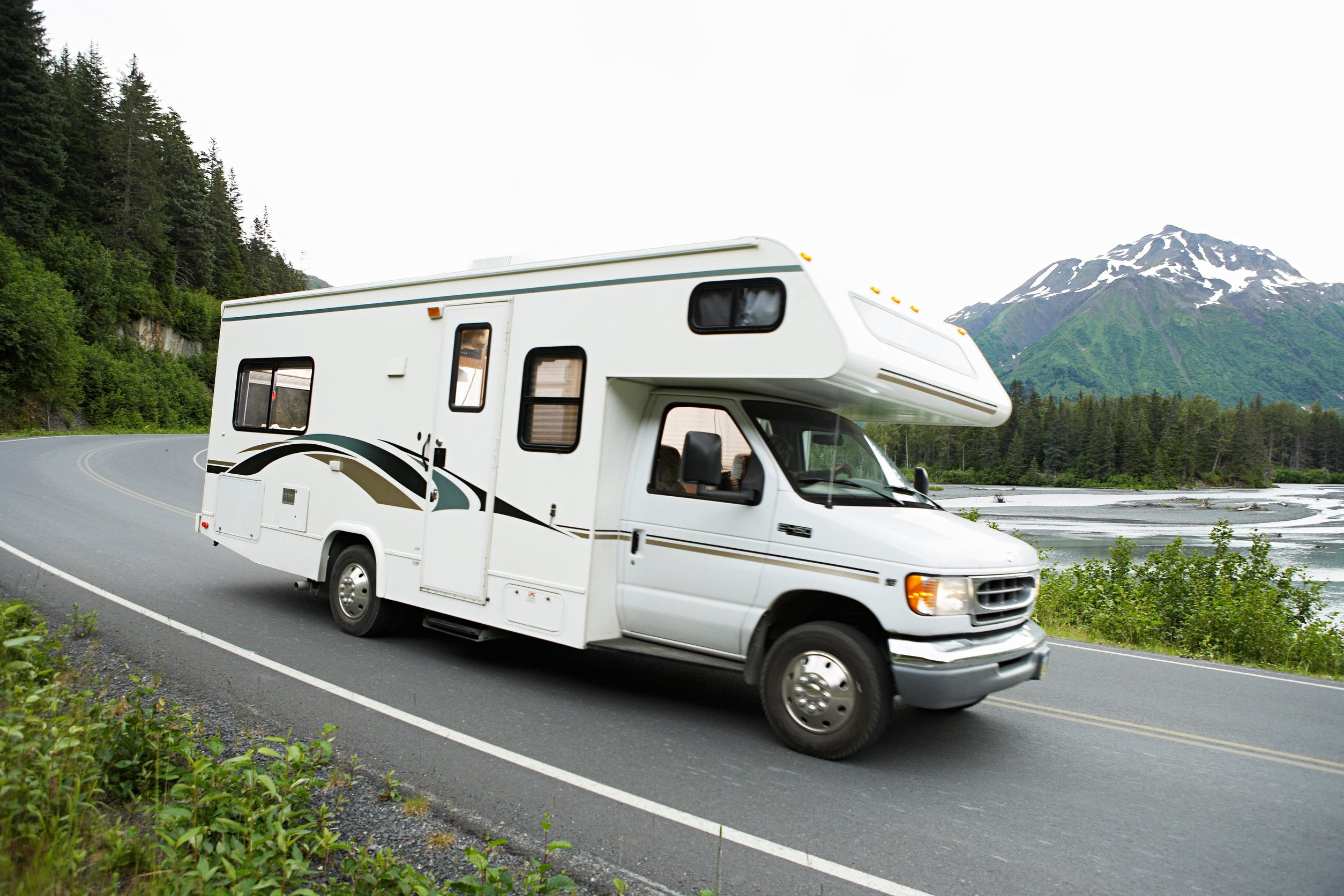 USA, Alaska, recreational vehicle driving on road, side view
