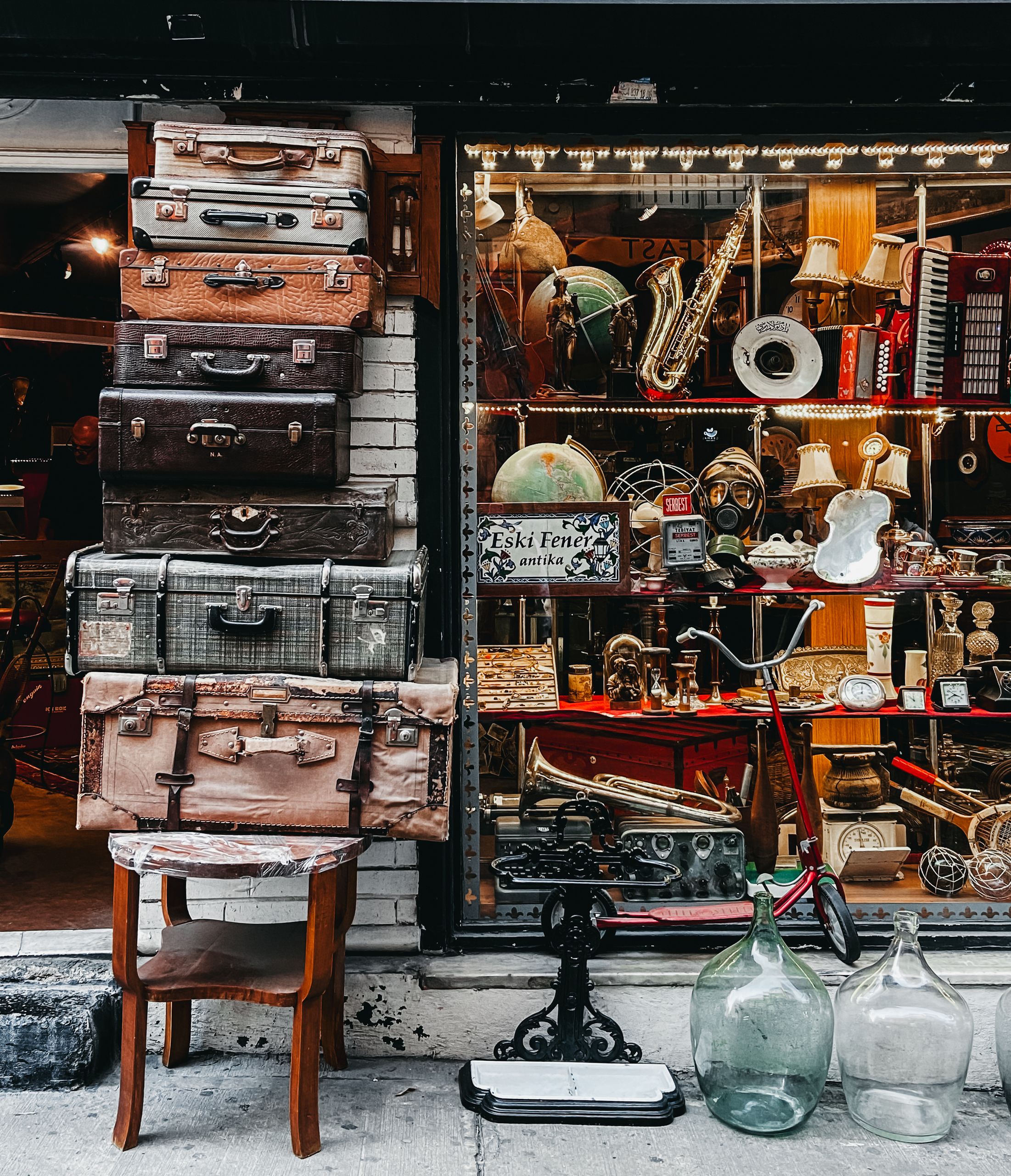 A collection of vintage suitcases and retro items displayed at an antique store.