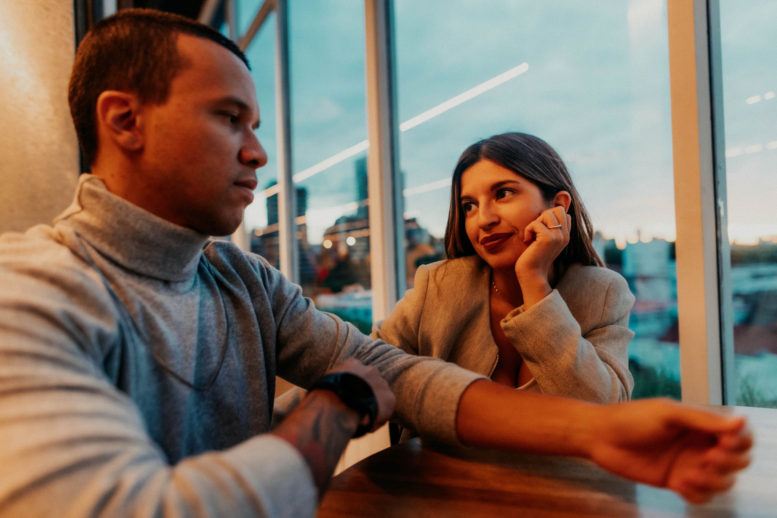 A couple sharing a romantic moment in a Buenos Aires cafe at sunset.