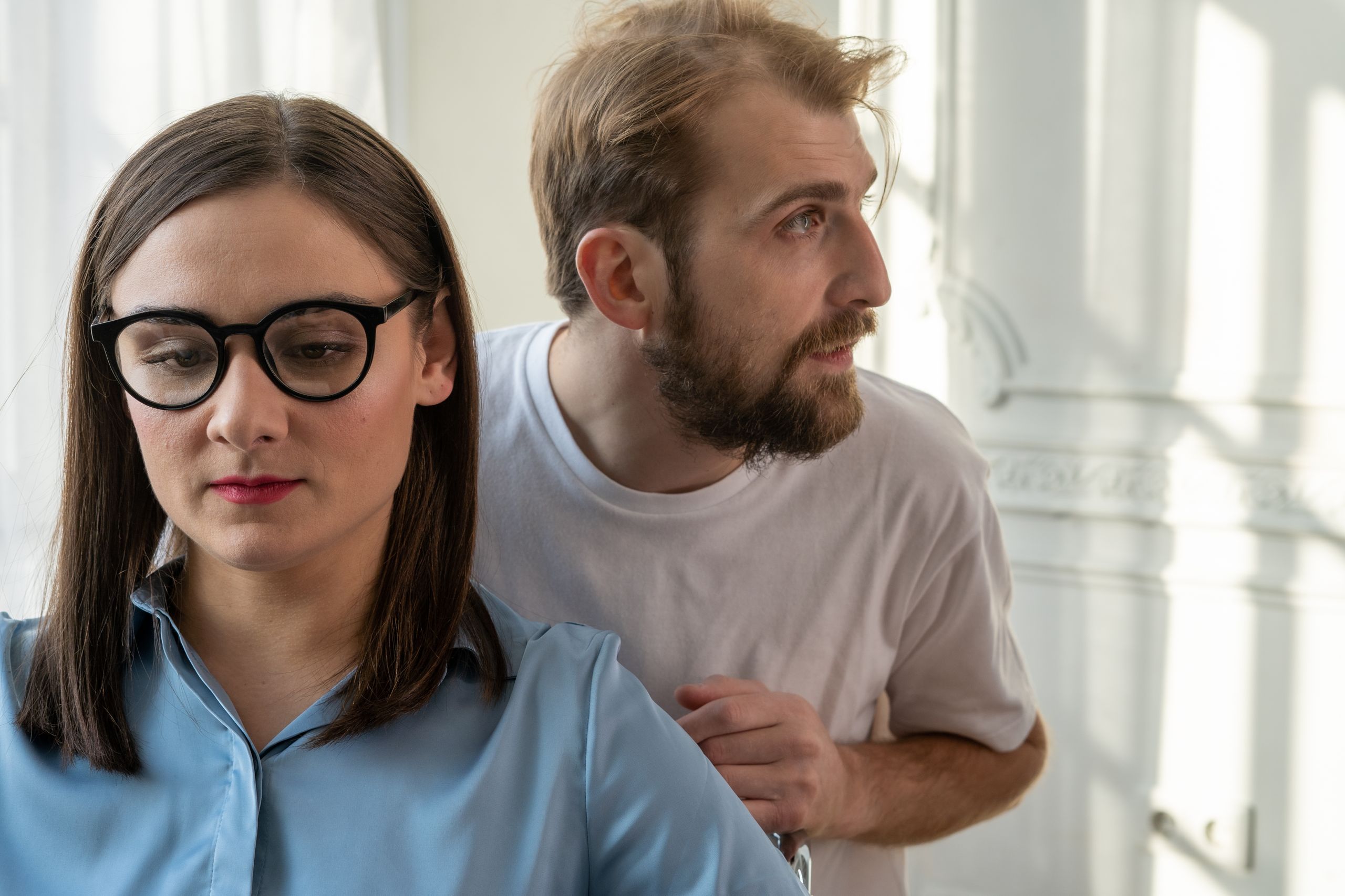 A serious conversation between a man and a woman in a modern office space, focusing on mental health consultation.