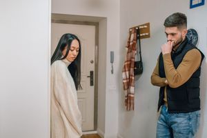 An interracial couple experiencing a tense moment inside their home.