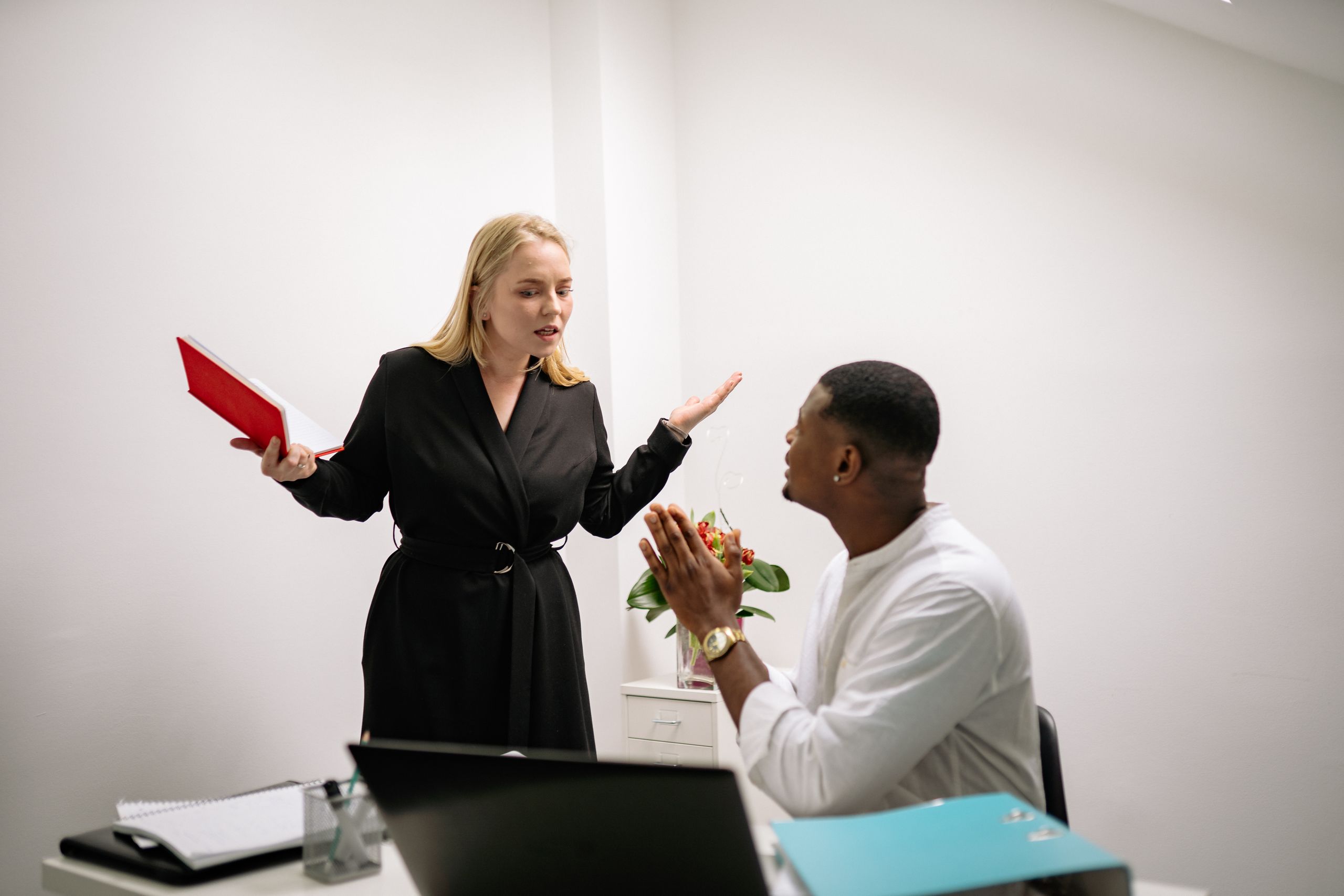 Colleagues in an animated discussion in an office setting, highlighting workplace communication.