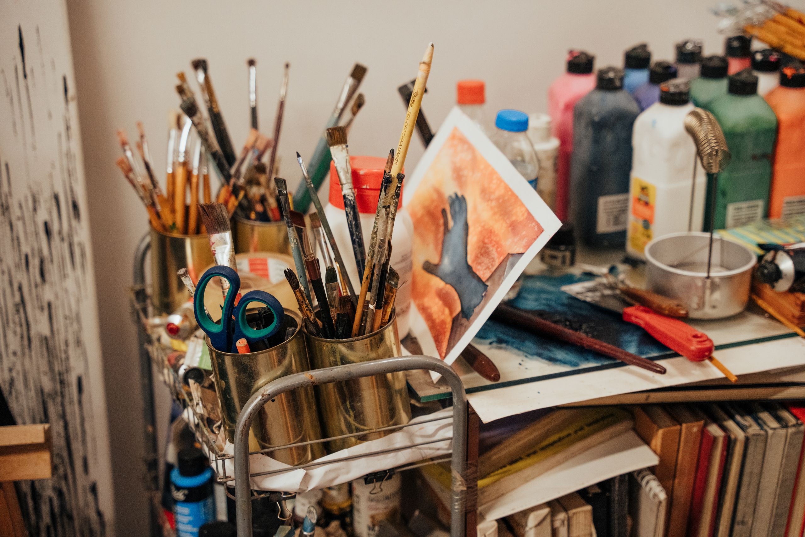 Colorful art studio corner with brushes, paints, and a painted canvas. Ideal for creative inspiration.