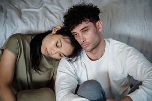 Couple sitting close, displaying emotional distance and contemplation.