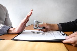 Anti bribery and corruption concept, Business man refusing and don't receive money banknote in envelop offer from business people to accept agreement contract of investment deal.