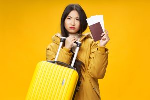 woman with yellow suitcase passport and plane tickets travel vacation airport