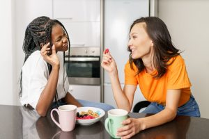 Two friends having a healthy snack while chatting at home