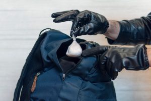 A police officer searches a drug dealer. I put the drugs in pocket. Committing a crime. Illegal drug possession. The drug courier was caught by the police.