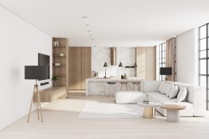 Minimalistic style living room with tv in wall, big white sofa on carpet and modern kitchen room on background. 3D rendering