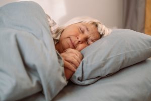 Beautiful 50s caucasian woman wearing pajamas sleeping in bed at home. Sweet Dreams