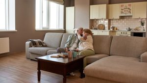 Grey hair european couple resting on sofa at home