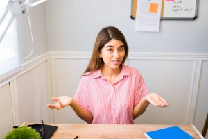 Beautiful latin woman looking at the camera while having a video call while working remotely at home