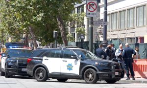 San Francisco, CA - Aug 12, 2023: Police arresting a protesteor during the 30th annual Pistahan Parade. Vehicles standing by with officers.