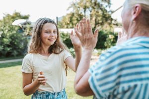 Grandmother and granddaughter playing clapping game.