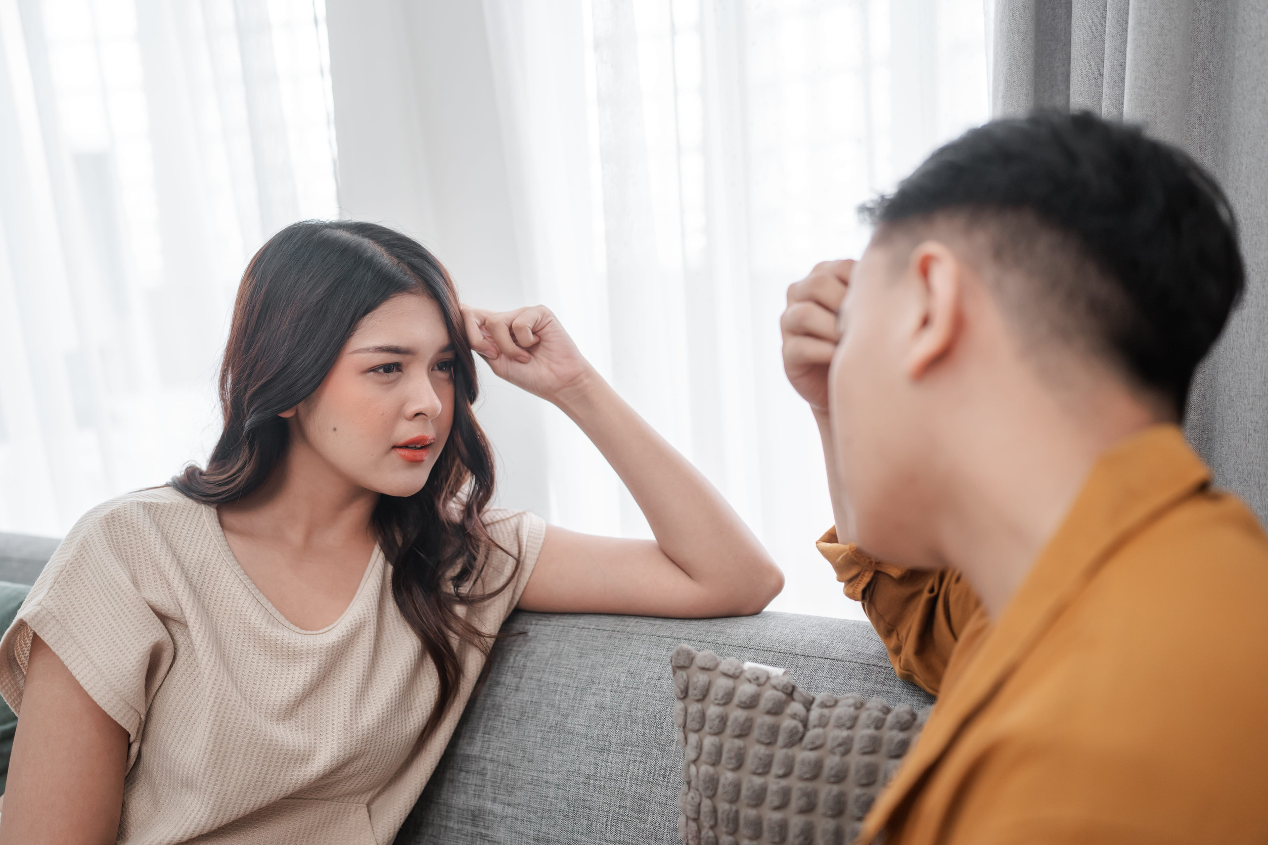 A couple shares a serious, heartfelt discussion at home, showcasing their genuine emotions