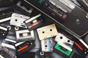 Collection of Cassette Tapes and a Tape Player Arranged in a Collage on a Surface