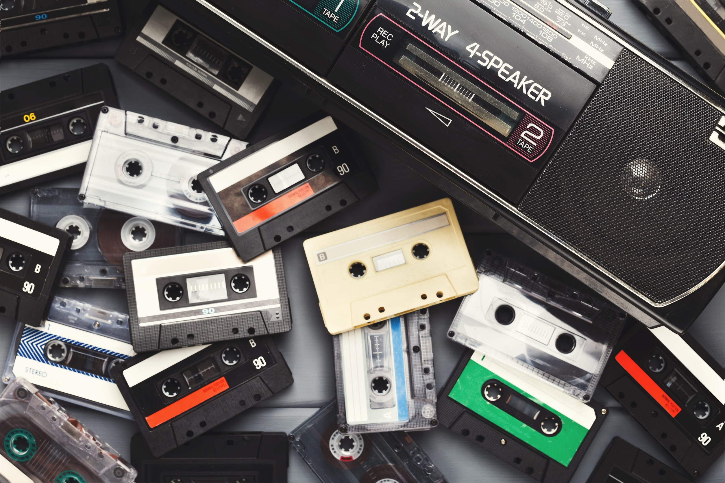 Collection of Cassette Tapes and a Tape Player Arranged in a Collage on a Surface