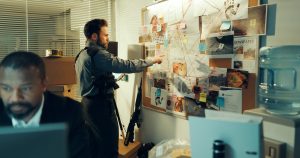 Detective, man and board with documents of evidence for case, investigation and criminal lead at police station. Investigator, problem solving and point with tablet for mindmap with suspect at night