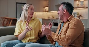 Argument, dispute and couple on sofa in home with conflict, disagreement or communication in marriage. Fighting, divorce and people in living room for accusation of cheating, affair or infidelity