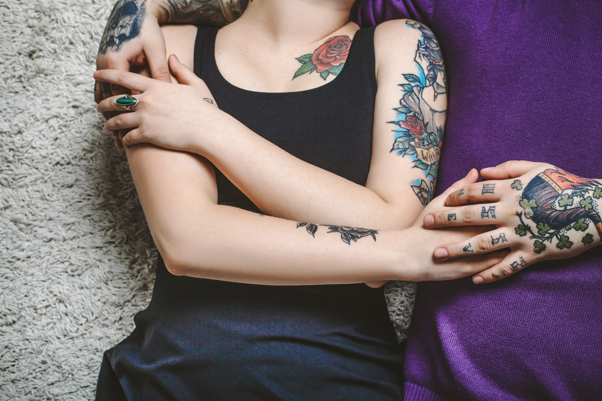 young couple in love, tattoos, cuddling and holding hands on the bed