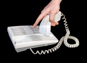 Hand dialing number isolated on black