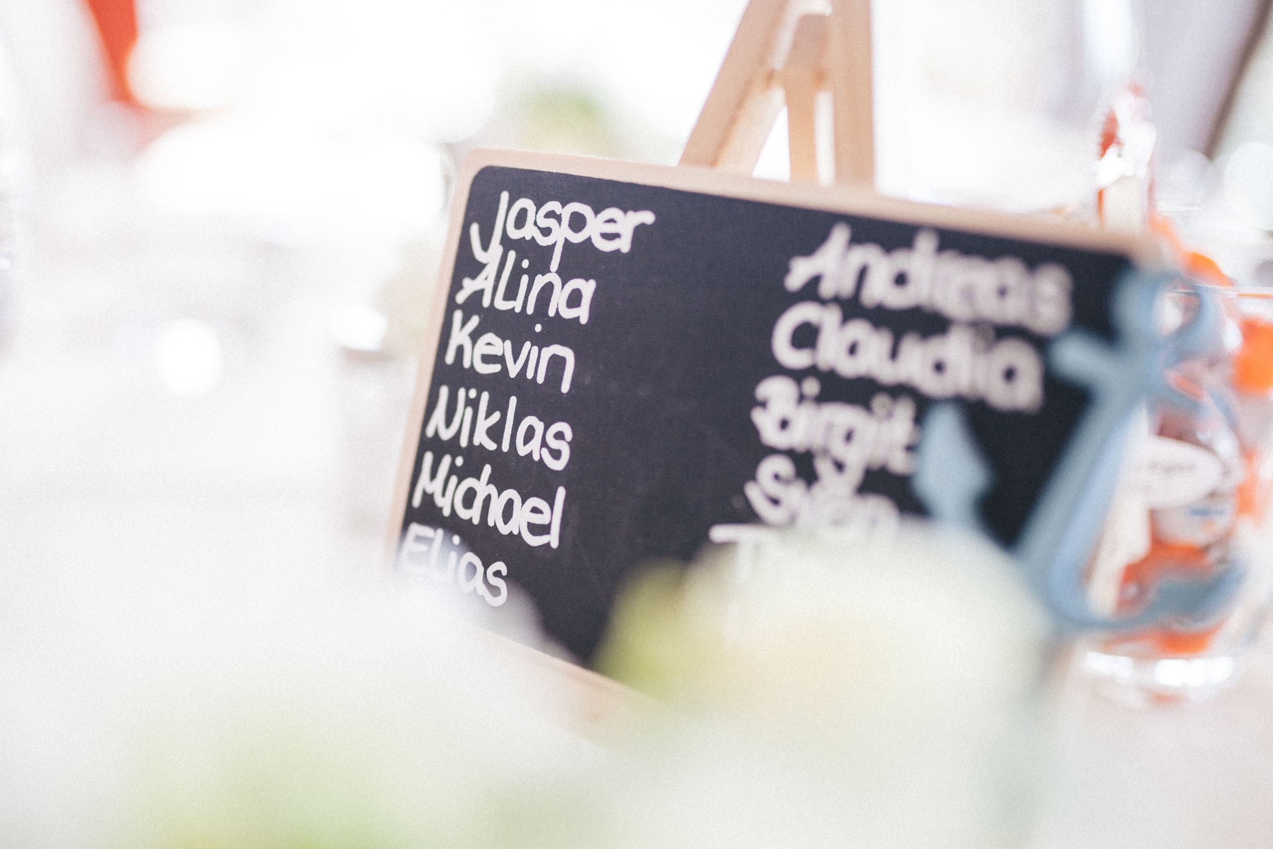 A decorative chalkboard displaying names at a refined indoor gathering.
