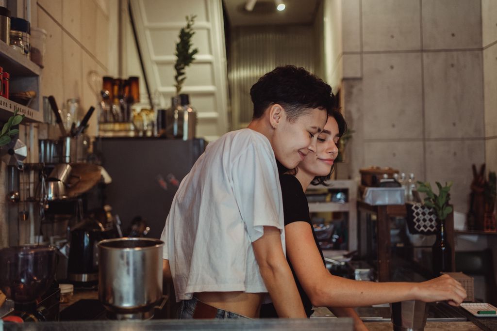 A joyful couple enjoying a warm moment together in a modern kitchen setting.