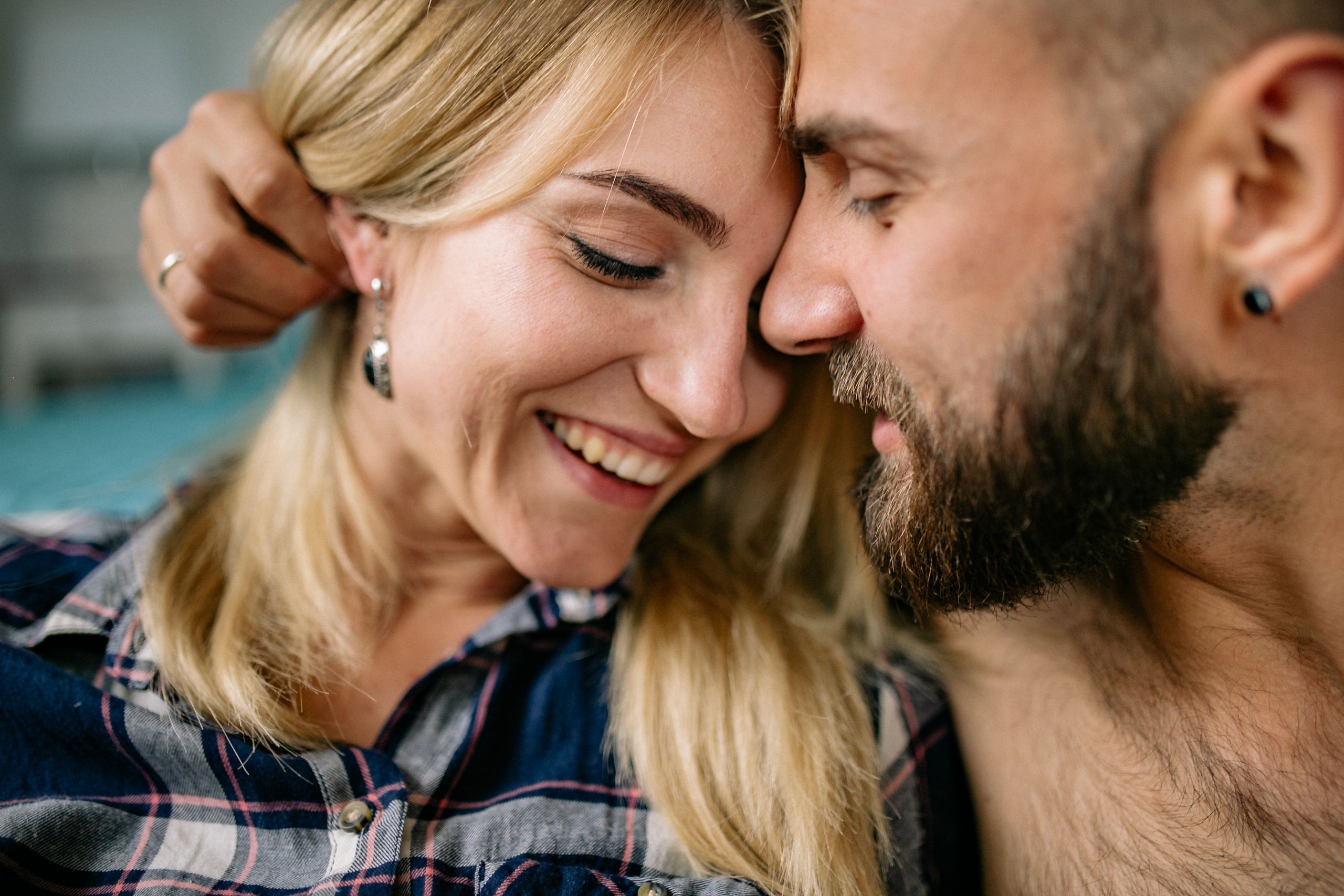 A warm, intimate moment between a smiling couple indoors