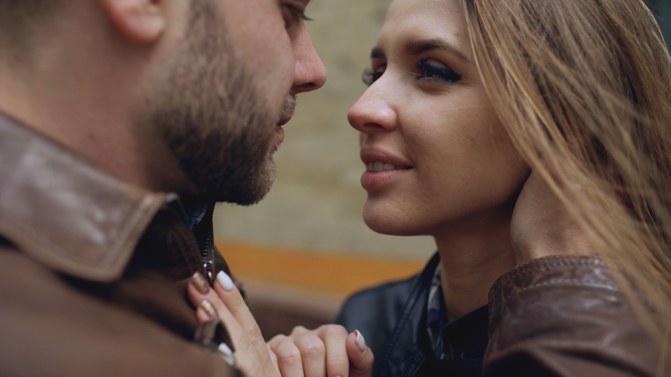 An intimate close-up of a couple embracing lovingly outdoors.