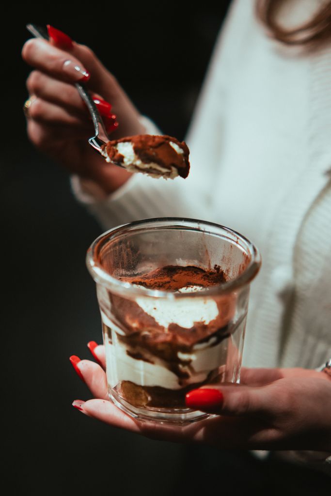 Close-up of hands holding a delicious tiramisu dessert in Arras, France.
