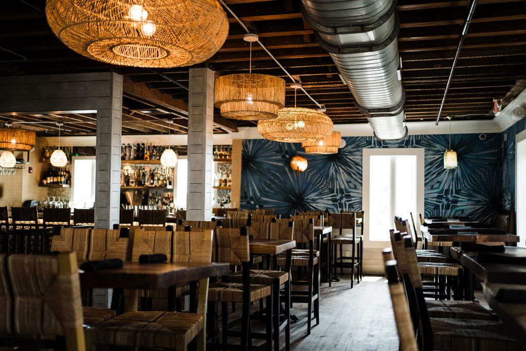 Cozy restaurant interior with wicker lamps and wooden furniture, St. Augustine, Florida.