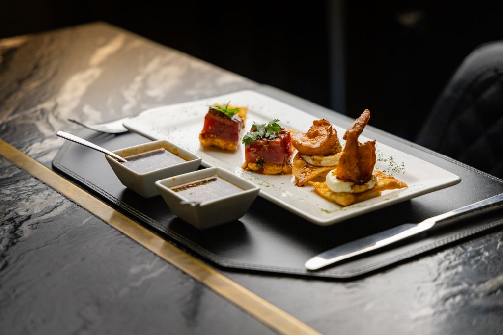 Delicious gourmet seafood appetizers presented in an elegant setting with dipping sauces.