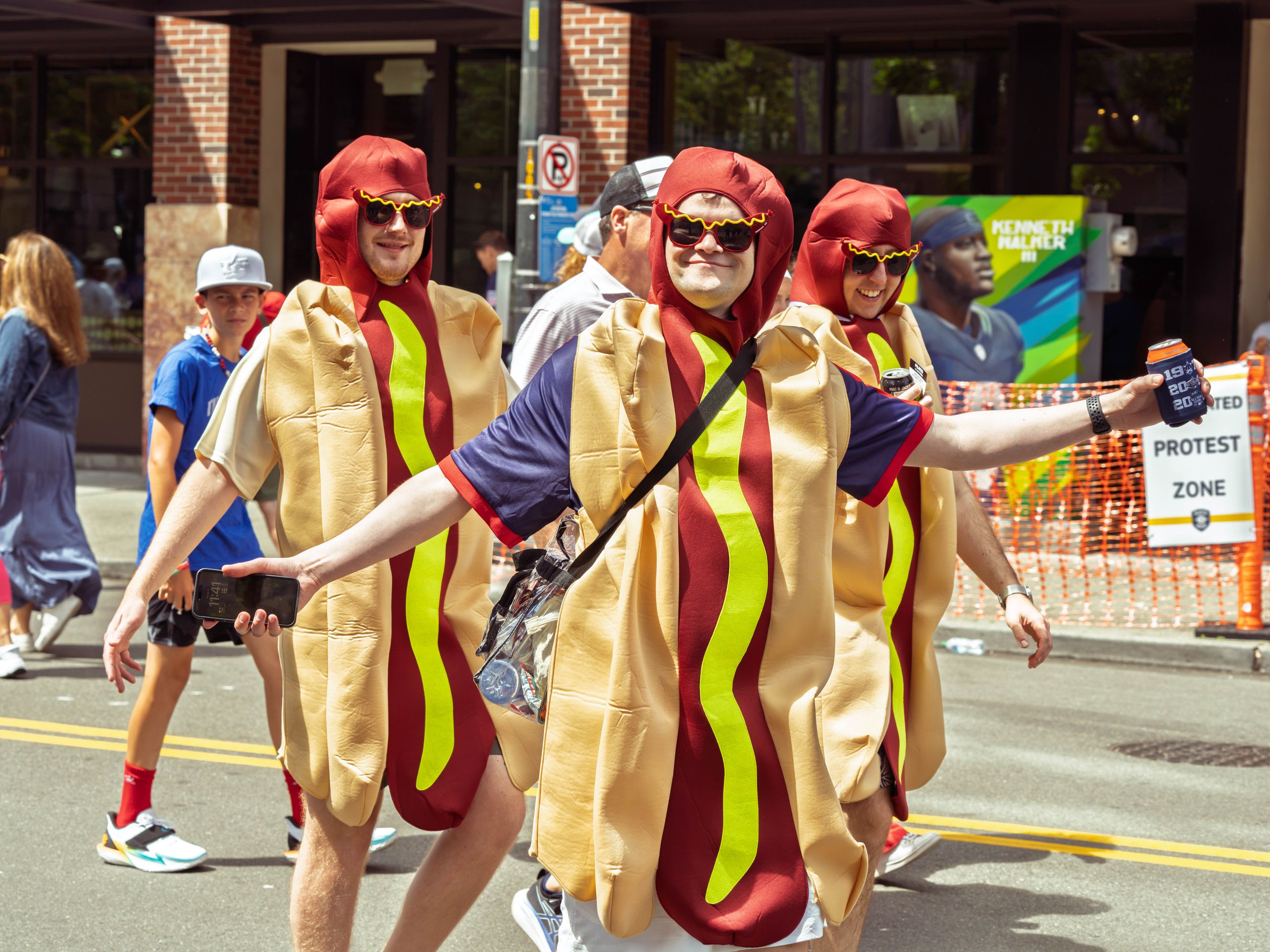 Group of adults in hot dog costumes enjoying a parade in vibrant Seattle.