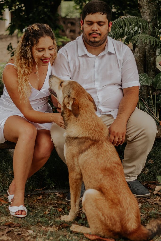 Happy couple relaxing outdoors with their dog, enjoying nature and companionship.