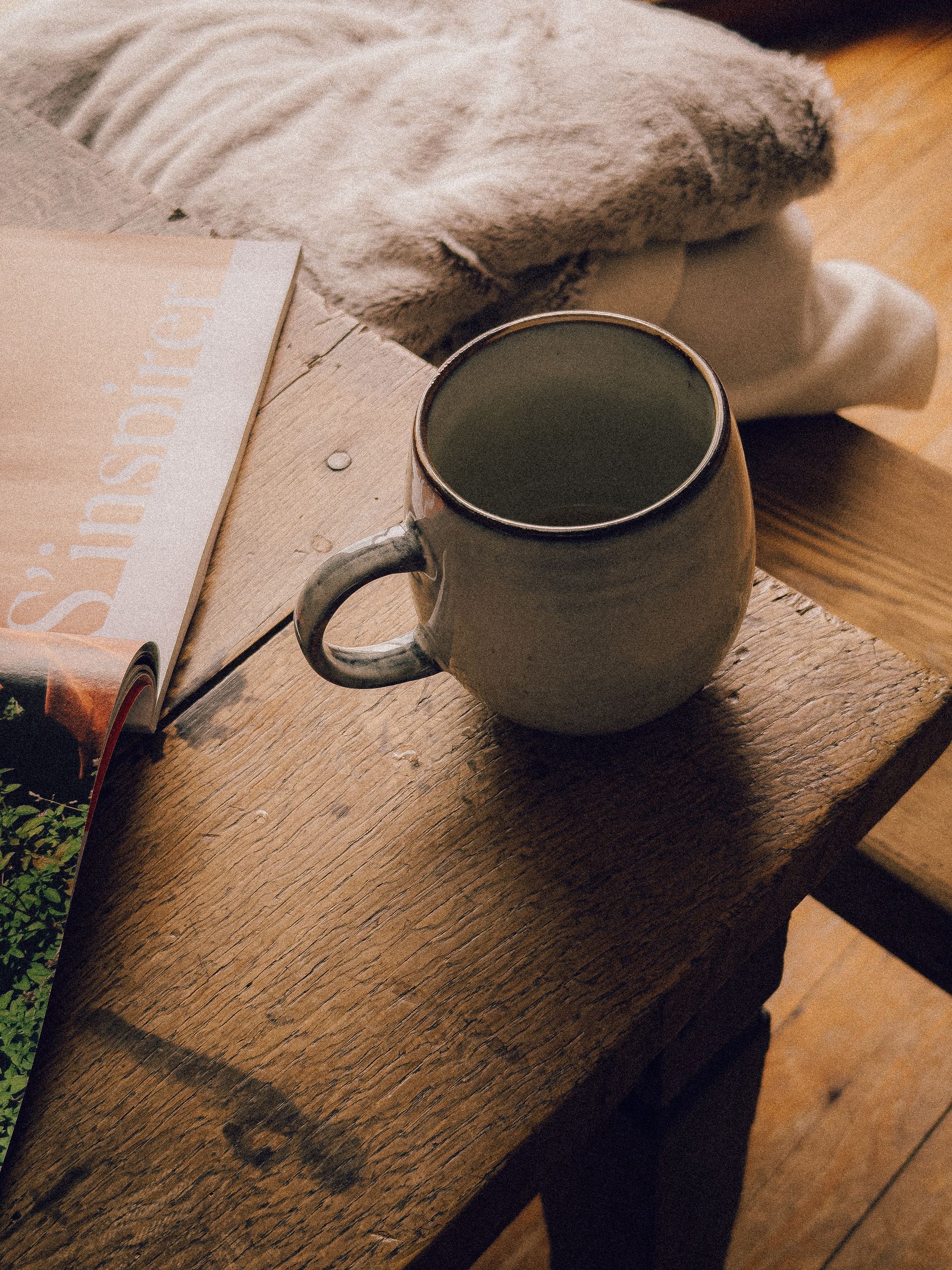 Rustic ceramic mug on a wooden table with a cozy ambiance, perfect for a peaceful morning in Paris.