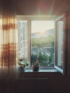 Serene sunrise through window with scenic landscape in Darende, Türkiye.
