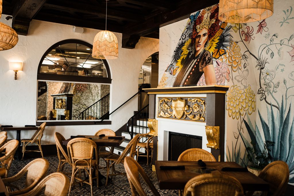 Stylish restaurant interior with mural art and wicker chairs in St. Augustine, Florida.