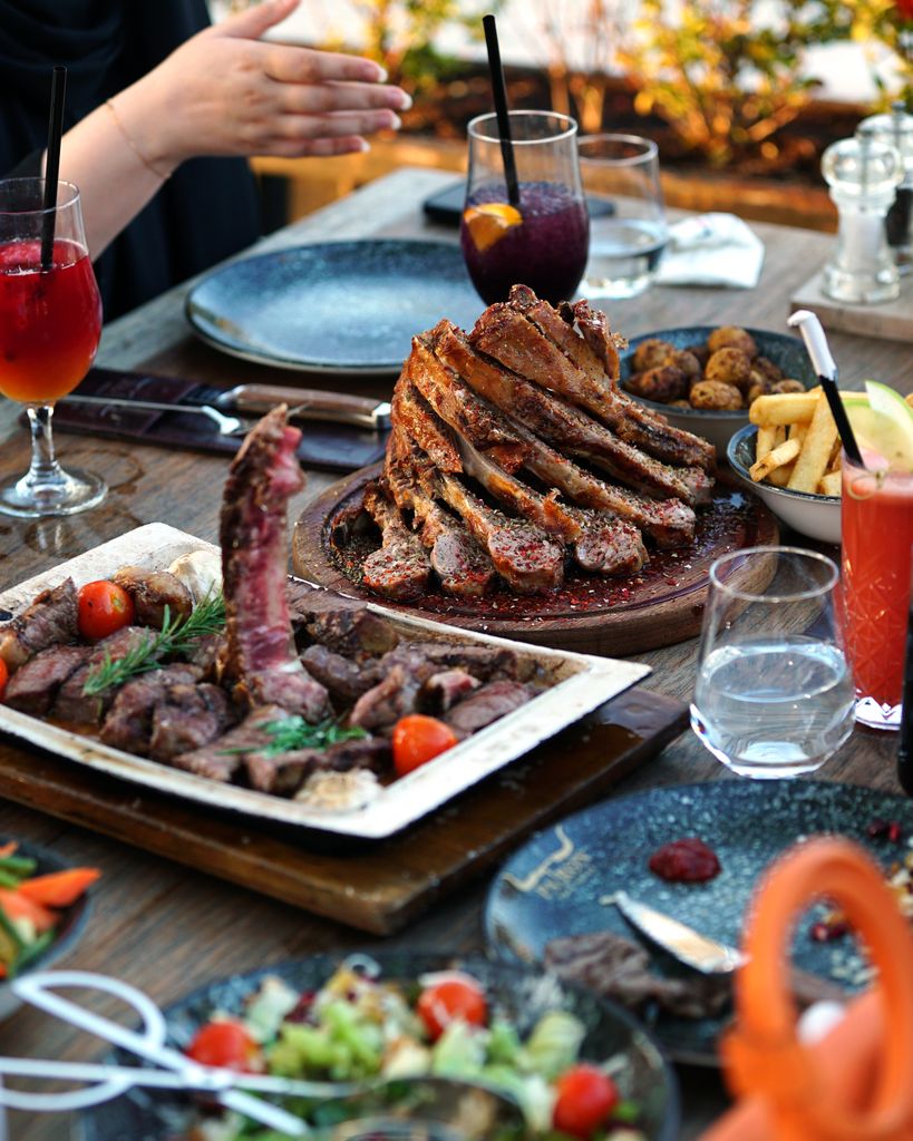 Sumptuous BBQ spread with grilled meats, fries, and refreshing cocktails outdoors.